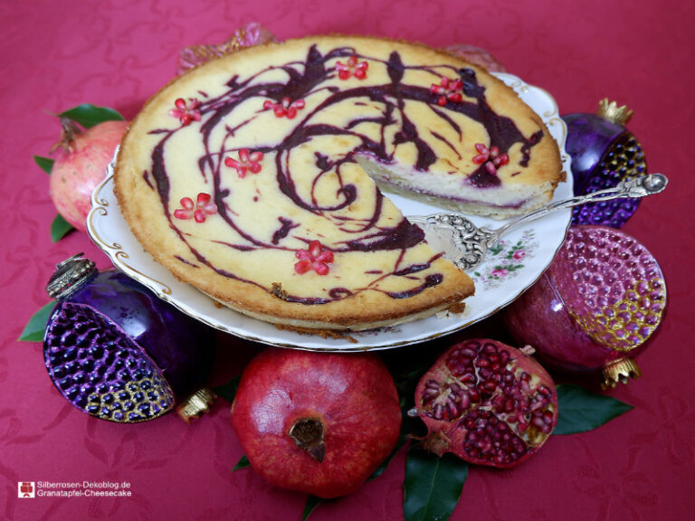 Granatapfel-Cheesecake ist ein Mürbteigboden mit einer Füllung aus Frischkäse und einem Topping von selbst gekochter Granatapfelsaice. Dekoriert mit Granatapfelkernen.