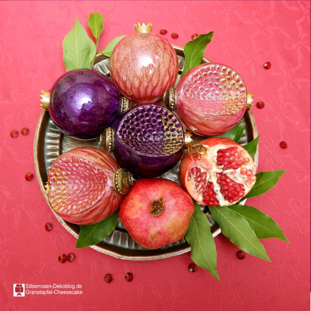 Zum Granatapfel-Cheesecake haben wir eine Dekoschale gestellt, gefüllt mit Granatapfeln. Das sind einmal echte Früchte, ganz und aufgebrochen. Und Glas-Granatäpfel sowie Deko-Rubine statt Kernen.