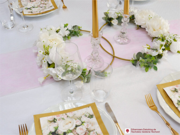 Tischdeko Goldene Hochzeit wirkt gut, wenn das Gold mit Weiß und Pastellfarben kombiniert wird. Zwei Goldene Ringe mti Blumen bilden den Mittelpunkt am Tisch.