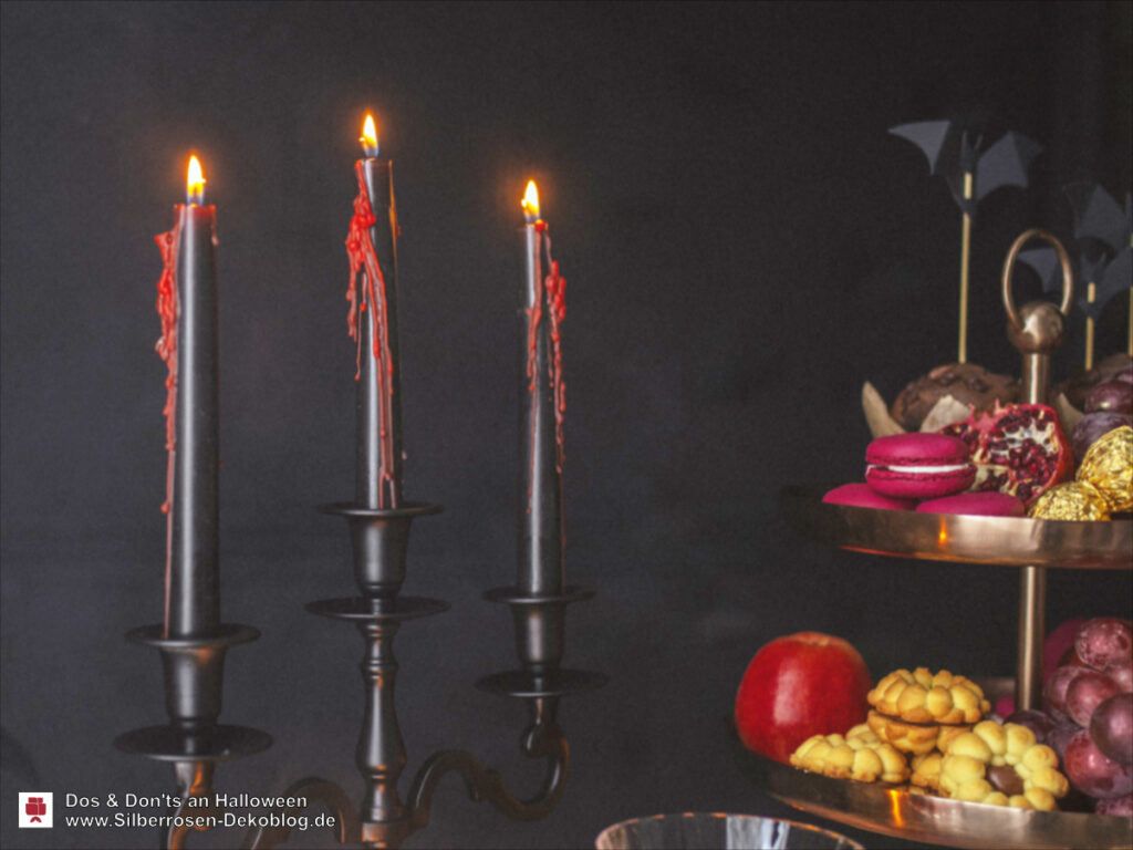 Schwarze Kerzen, aus denen blutrotes Wachs schmilzt und an den Kerzen herunterrinnt.