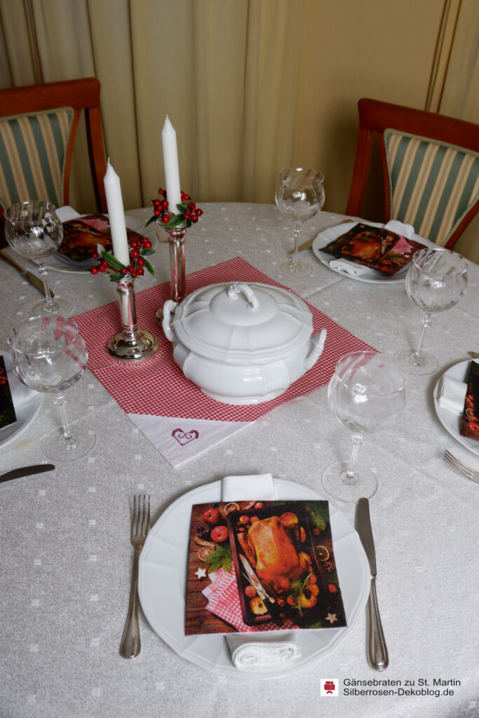 Servietten mit Gänsebratenmotiv und rotes Bauernkaro, Kerzenkränzchen mit roten Beeren machen die Deko für die Martinsgans.