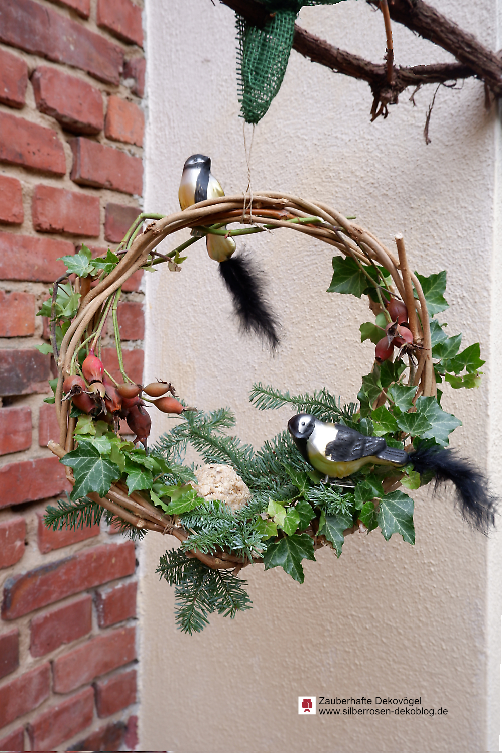 Winterlicher Kranz aus Zweigen mit Dekovögeln aus Glas zum Anklipsen.