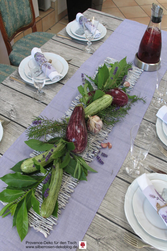 Provence-Deko mit Lavendel, Gemüse und gedecktem Tisch.